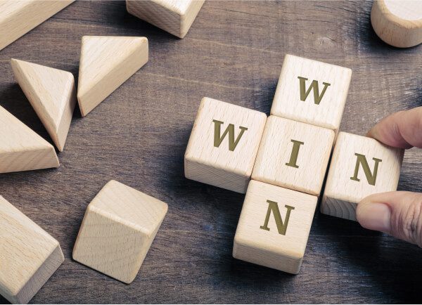 wooden scrabble cube with word win at The Worx Real Estate